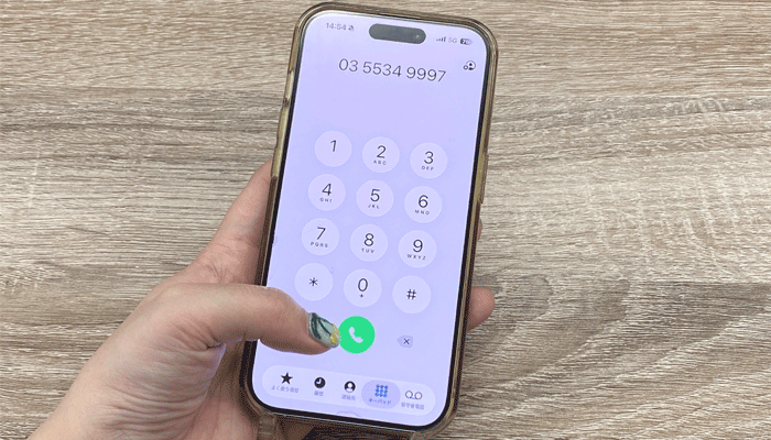 電話をして問い合わせしている人の写真