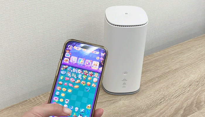 ホームルーターとゲーム画面が映ったデバイスの写真