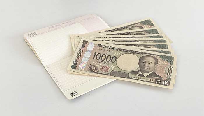 通帳とお金の画像