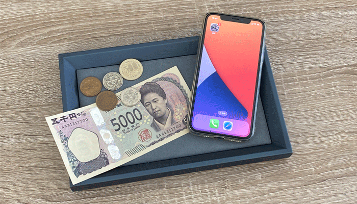 スマホとお金を一緒に写した写真