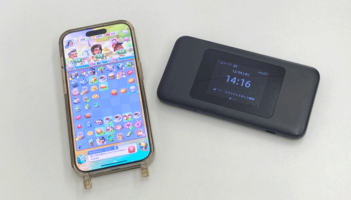 スマホとポケット型WiFiをそばに置いてオンラインゲームをしている写真